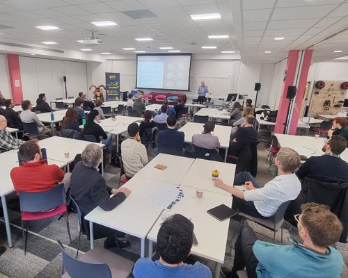 news_launch_03 Photo showing a room of people seated around tables watching a presentation at the prosquared launch event