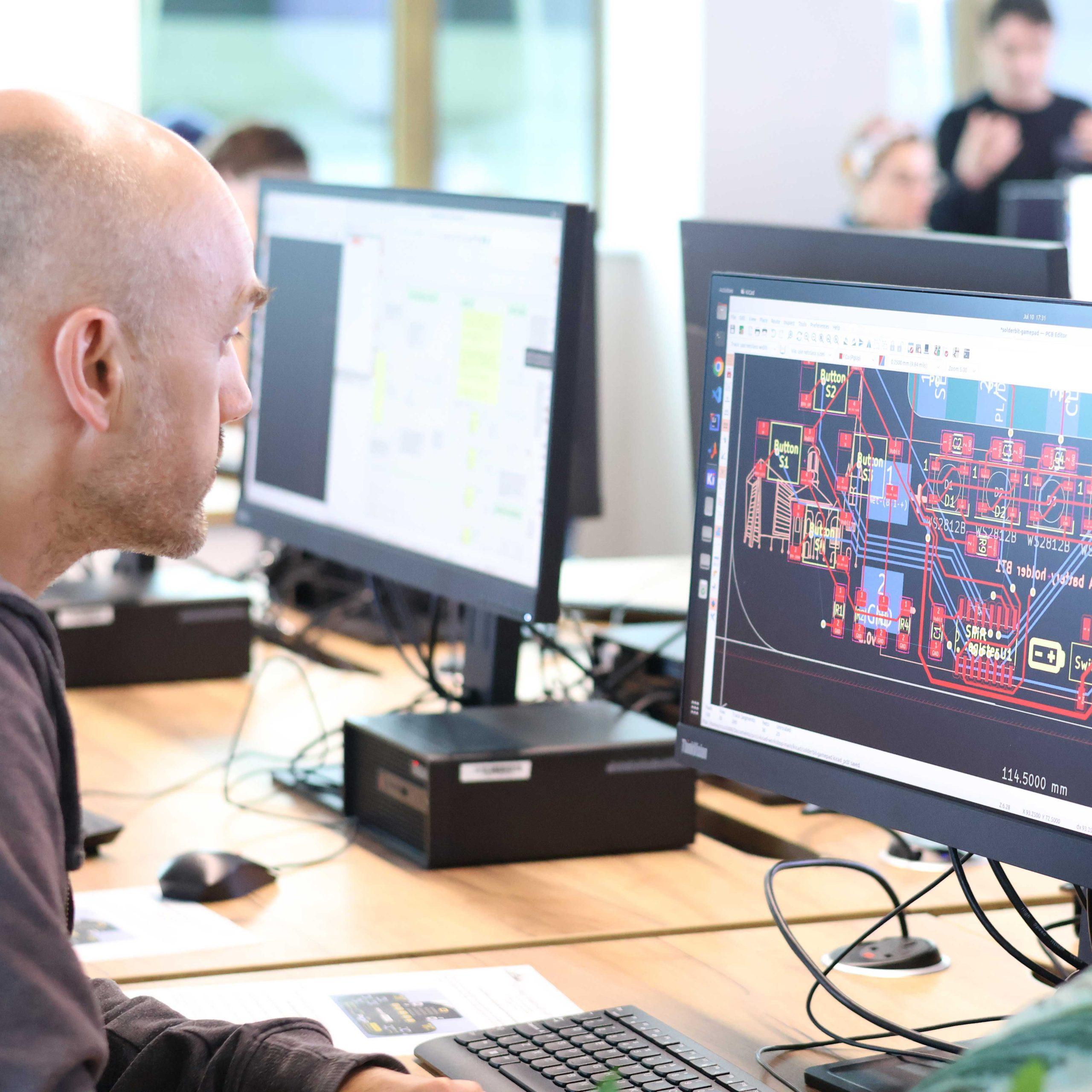 07 A person looks at a computer screen displaying coding information in a lab.