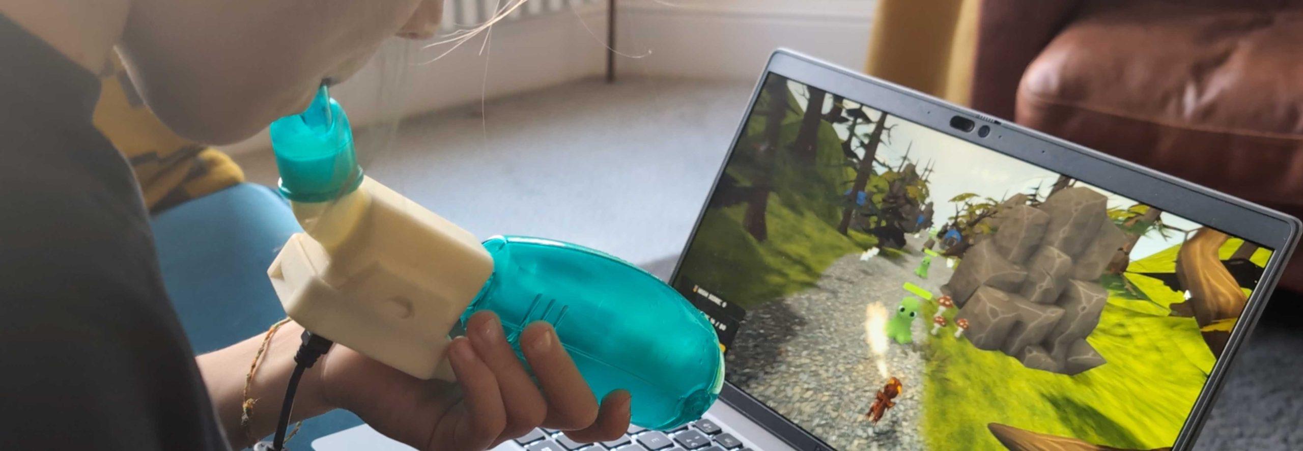 robust_game A child using a chest physiotherapy device with an embedded electronic component, allowing it to also serve as a game controller. A computer screen shows a video game with a woodland fantasy setting.