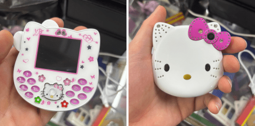 A person's hand is shown holding a Hello Kitty themed phone, shaped like Kitty's head.