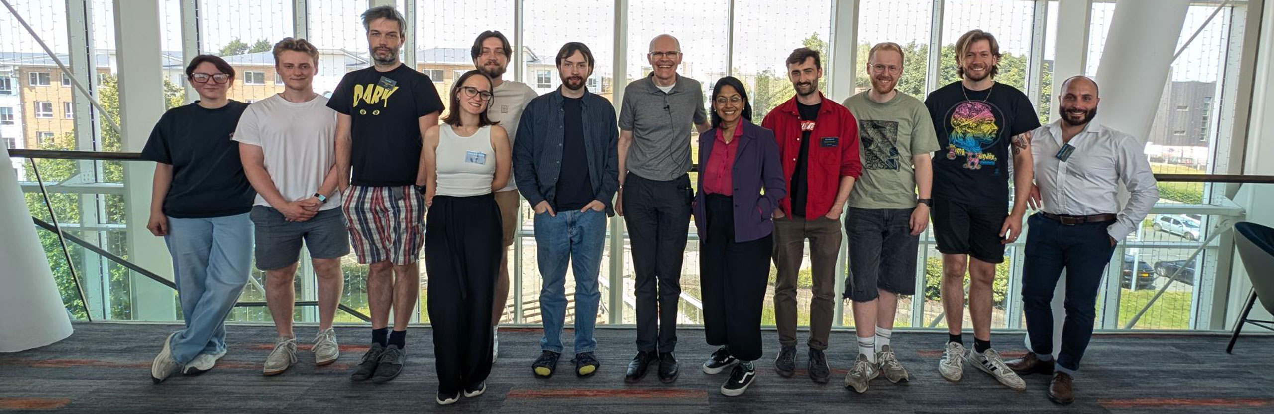 winner_group Summer school prize winners stand in a row with event organiser Professor Steve Hodges in a Lancaster University building, with a large window behind them.